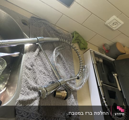 ברז מטבח מפורק על מגבת ליד כיור